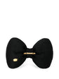 Chanel satin bow brooch with elegant design, featuring a smooth satin finish and decorative bow shape on a plain background.