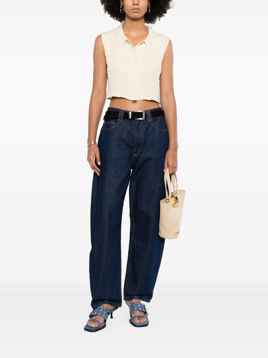Beige Chanel cropped collared vest displayed on a hanger, showcasing its stylish collar and tailored fit.