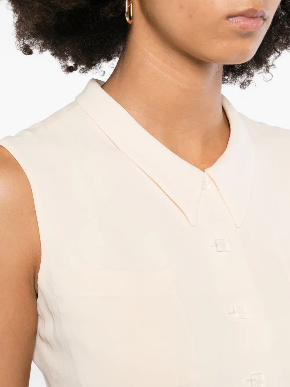 Beige Chanel cropped collared vest displayed on a model, featuring a tailored fit and classic design.