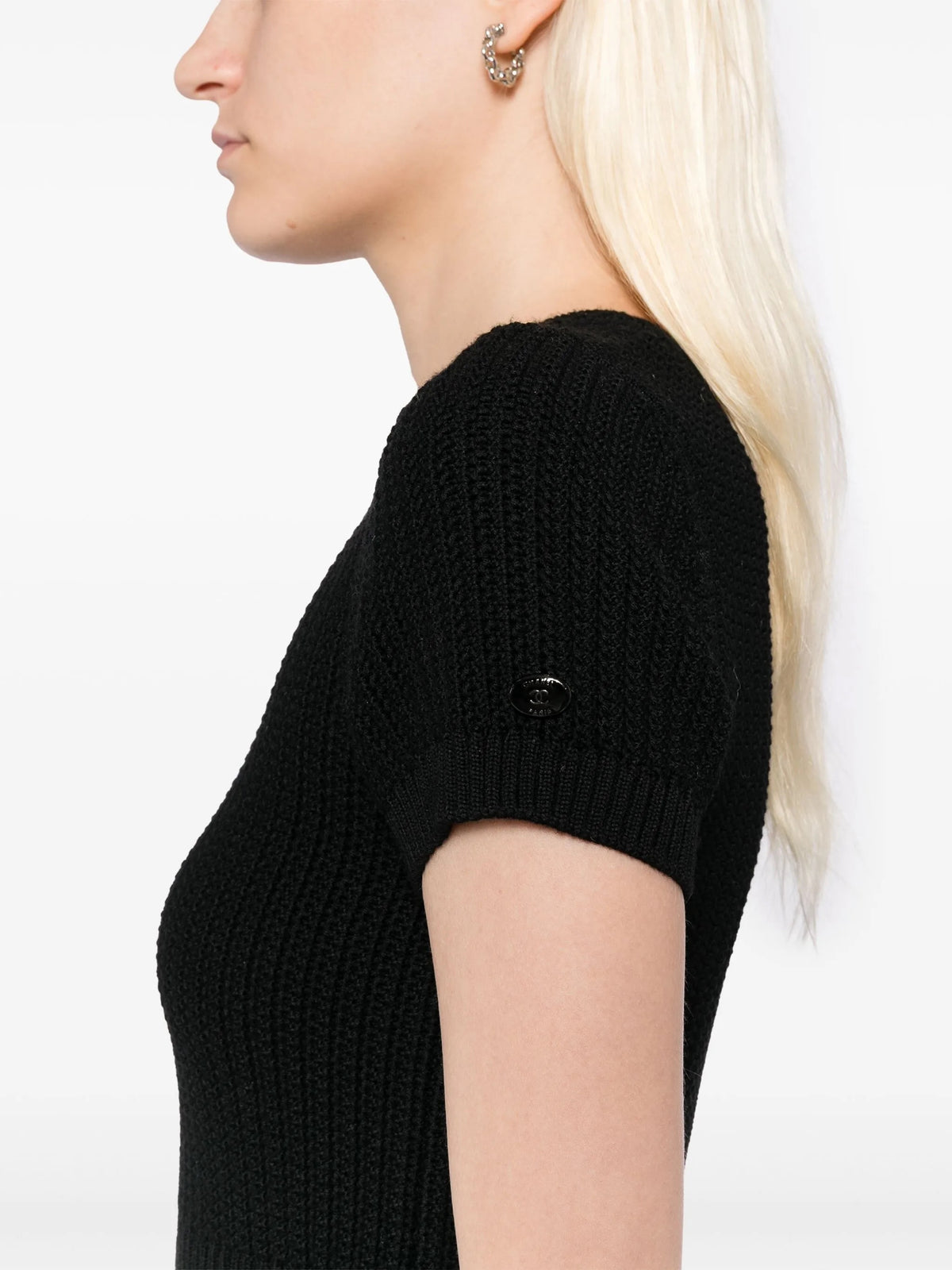 Black Chanel short-sleeve wool dress with a fitted silhouette and classic design, shown on a model.