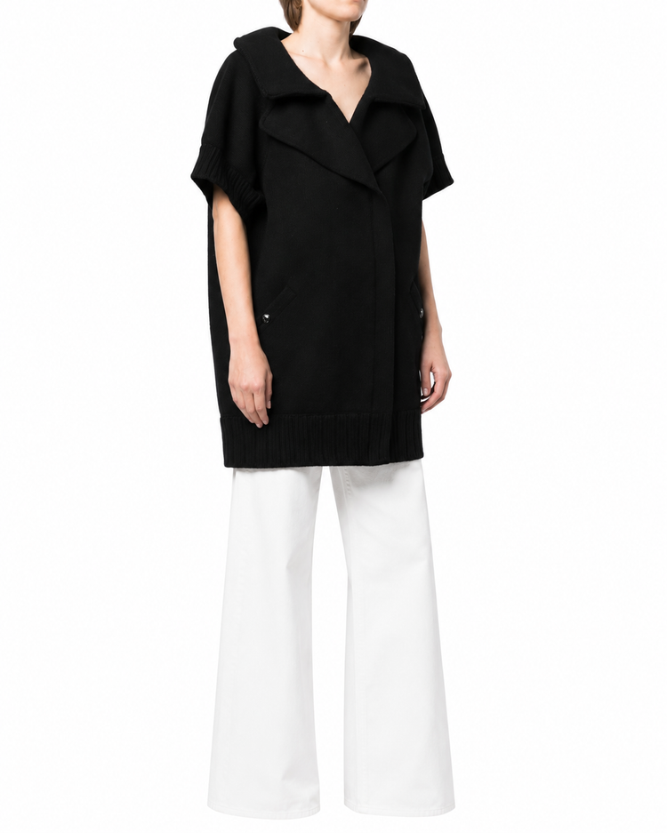 Black Chanel short-sleeved knit gilet, a stylish blazer or jacket with a fitted design and classic logo detailing.