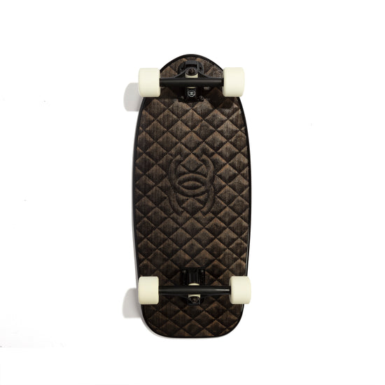 Chanel black skateboard deck with textured grip surface and large gold interlocking CC logo at the centre.