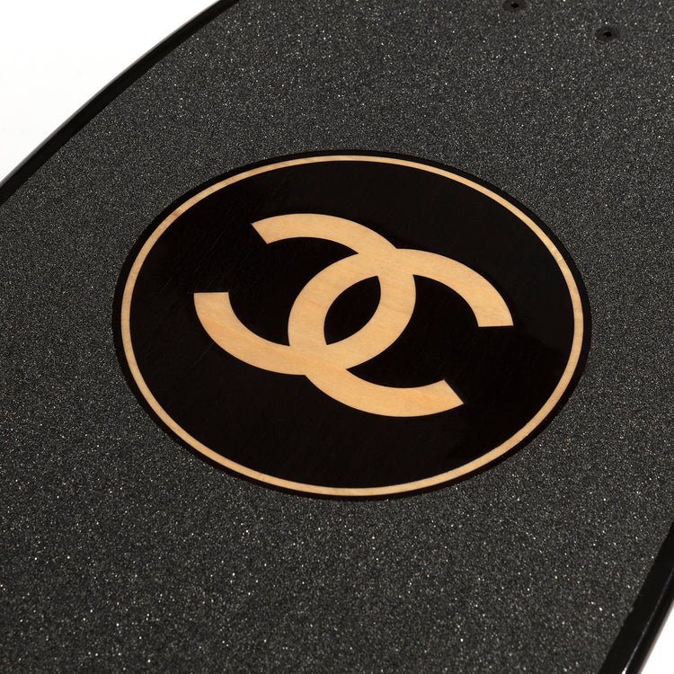 Chanel black skateboard deck with textured grip surface and large gold interlocking CC logo at the centre.