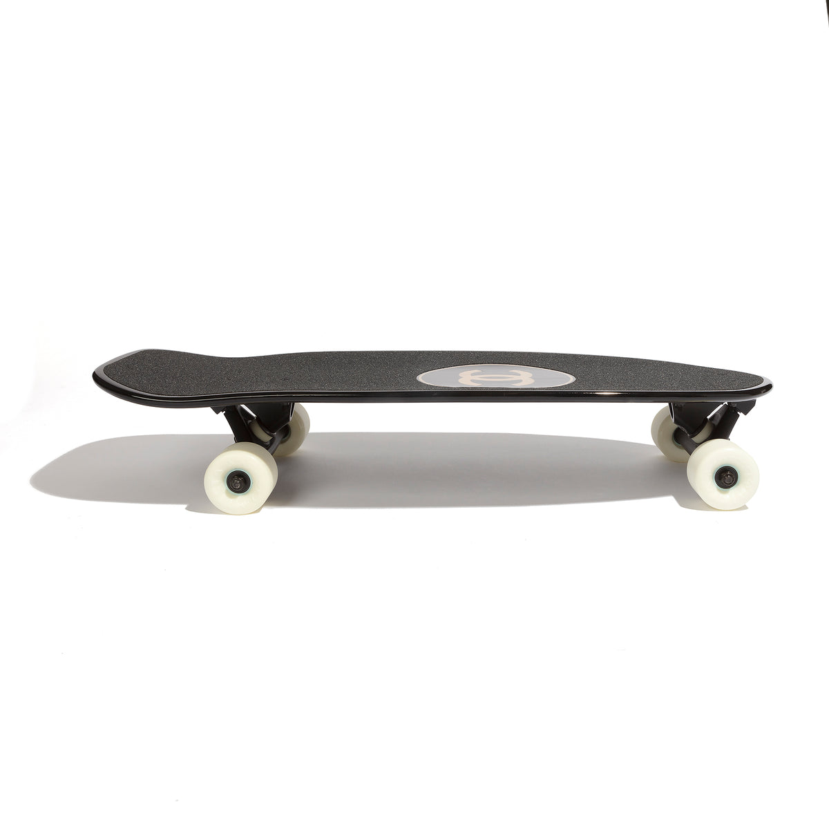 Chanel black skateboard deck with textured grip surface and large gold interlocking CC logo at the centre.