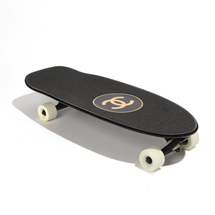 Chanel black skateboard deck with textured grip surface and large gold interlocking CC logo at the centre.