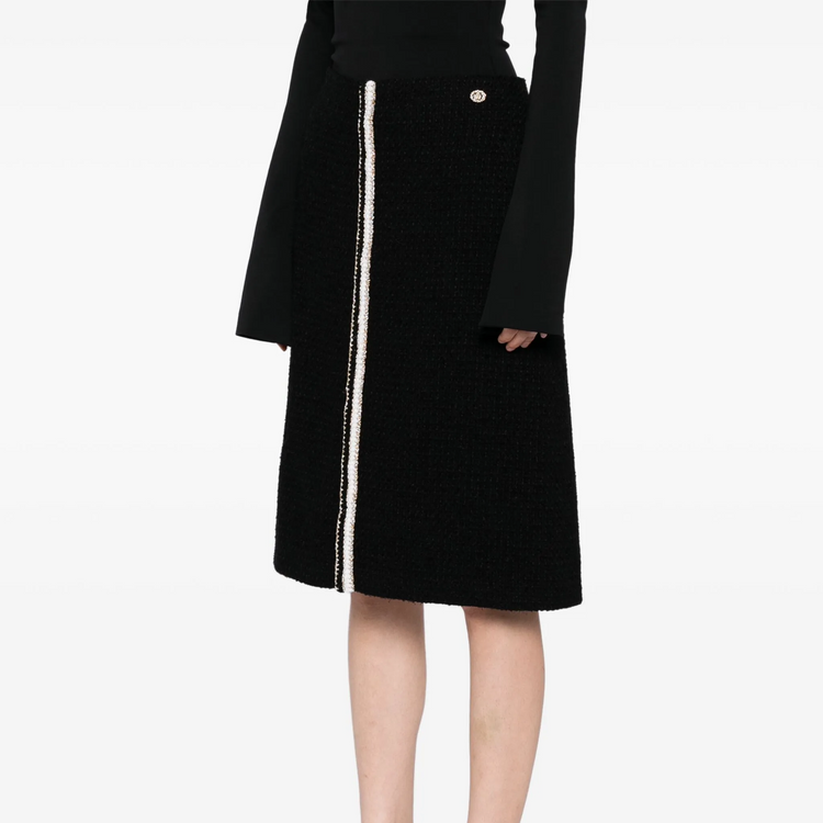 Black tweed Chanel skirt in knee-length style, featuring classic textured fabric and elegant design for stylish everyday wear.