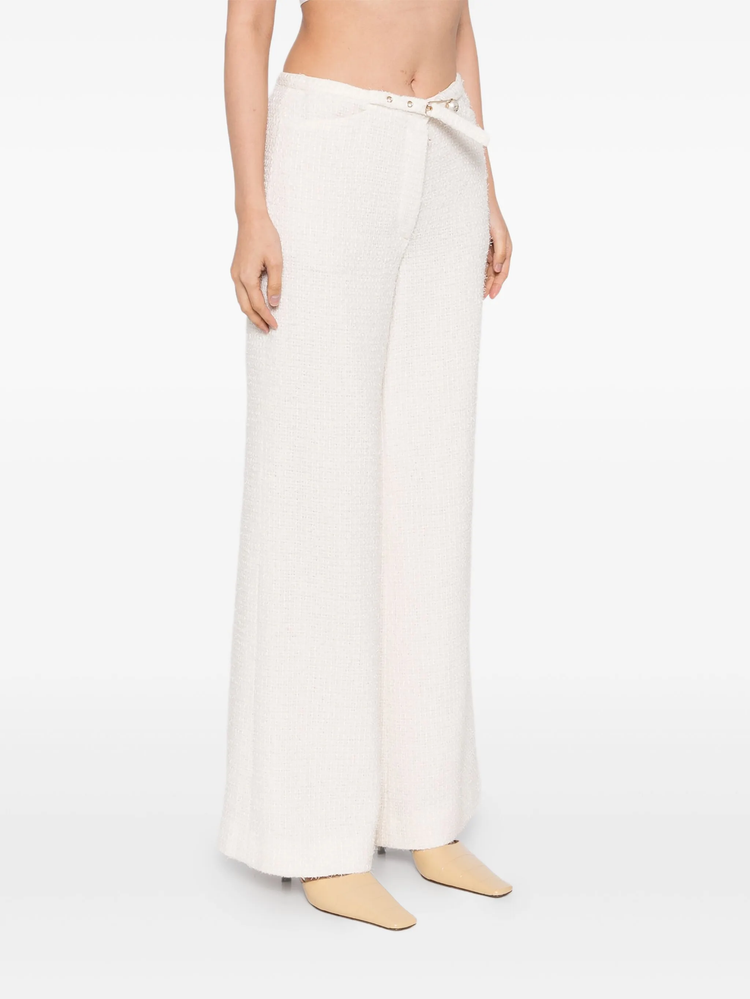 Cream Chanel tweed trousers featuring classic tailored design and textured fabric, displayed on a neutral background.