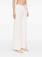Cream Chanel tweed trousers featuring classic tailored design and textured fabric, displayed on a neutral background.
