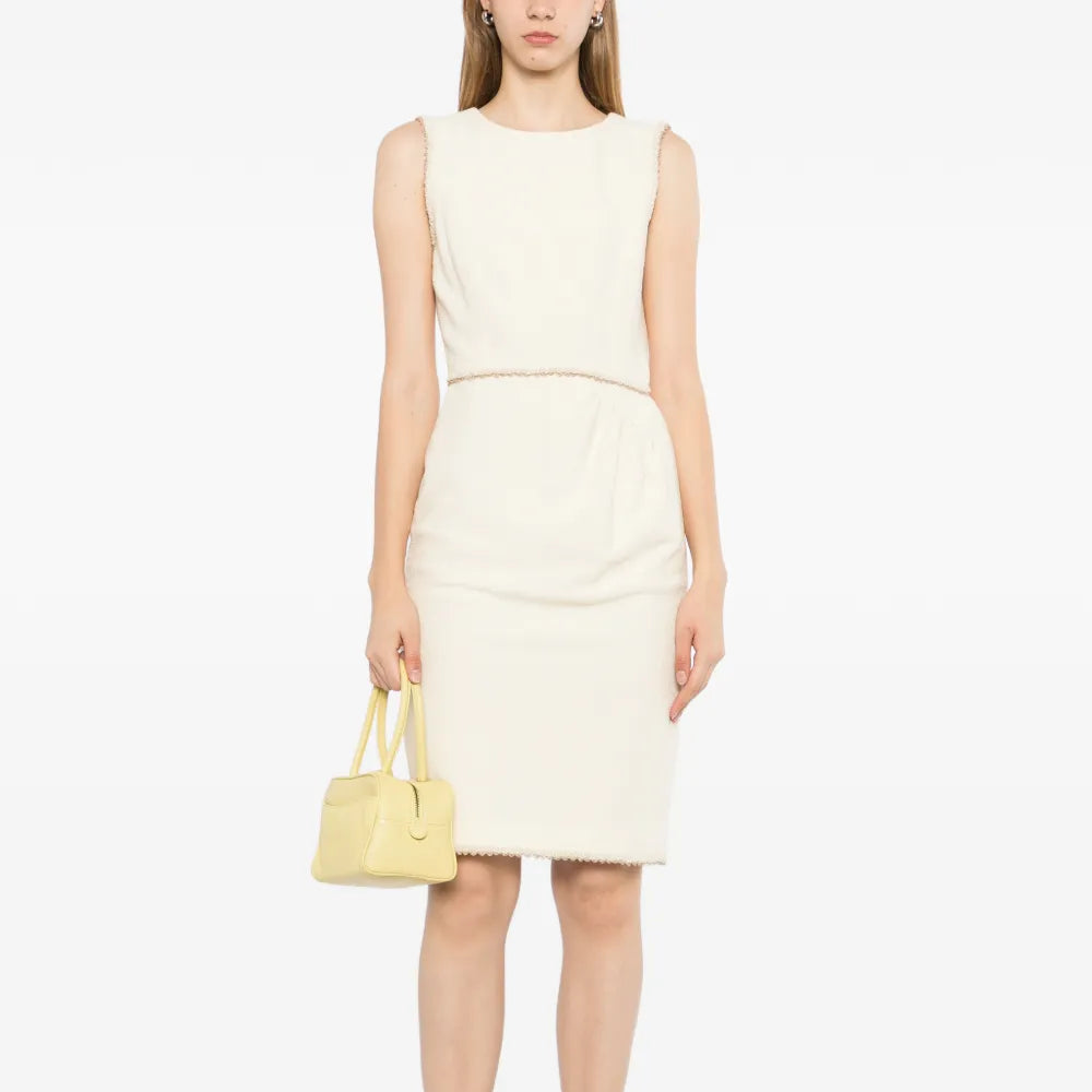 Chanel sleeveless cream wool tweed dress with fitted silhouette and classic round neckline, displayed on a mannequin.