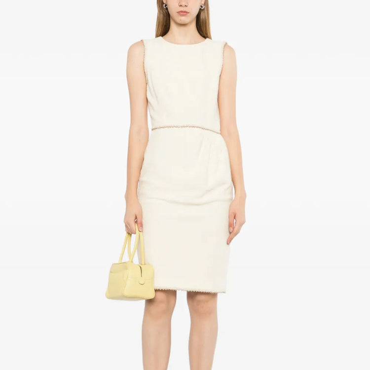 Chanel sleeveless cream wool tweed dress with fitted silhouette and classic round neckline, displayed on a mannequin.