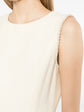 Chanel sleeveless cream wool tweed dress with a fitted silhouette and classic textured fabric, suitable for elegant occasions.