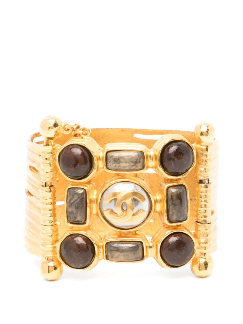 Vintage Chanel wide gold-plated cuff bracelet featuring amber Gripoix glass cabochons and a central frosted medallion with the interlocking CC logo.