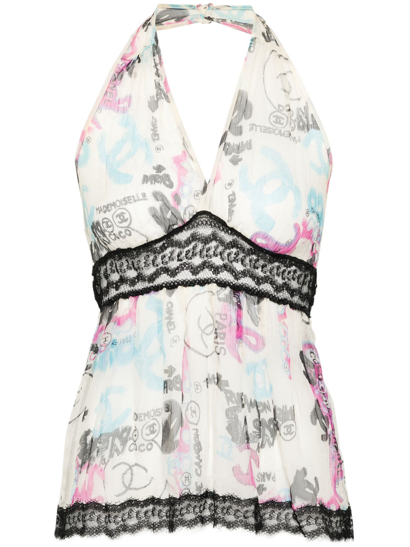 Chanel ivory silk halterneck top with multicolour graffiti print, deep V neckline, black lace underbust trim, flared silhouette and Chanel CC motifs.
