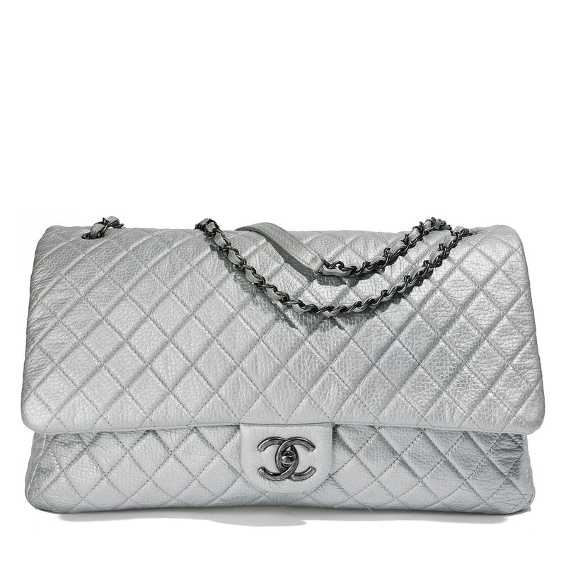 Metallic silver Chanel XXL airline travel flap bag with shoulder strap, showcasing its stylish design and spacious interior.
