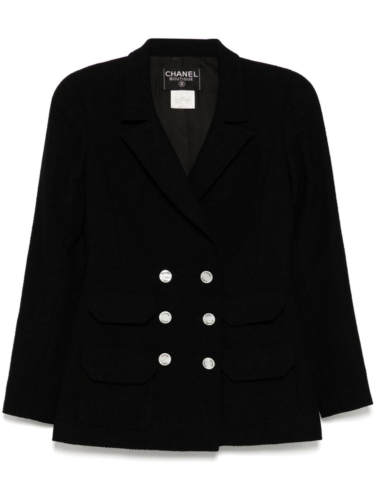 Navy double-breasted Chanel blazer with structured lapels and tailored fit, showcasing classic elegance and high-quality fabric.