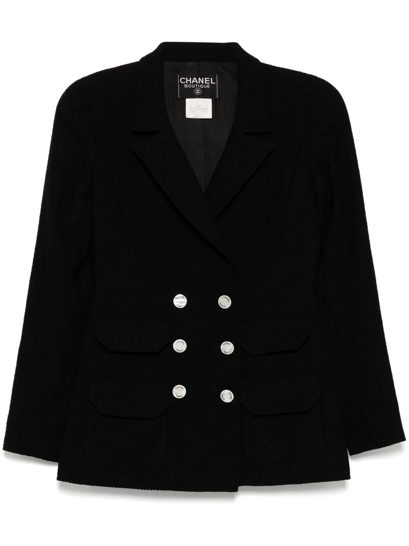 Navy double-breasted Chanel blazer with structured lapels and tailored fit, showcasing classic elegance and high-quality fabric.