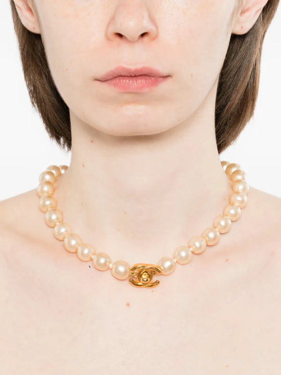Chanel Coco Turn-Lock pearl choker necklace with elegant clasp and layered pearl design, stylish jewelry accessory.