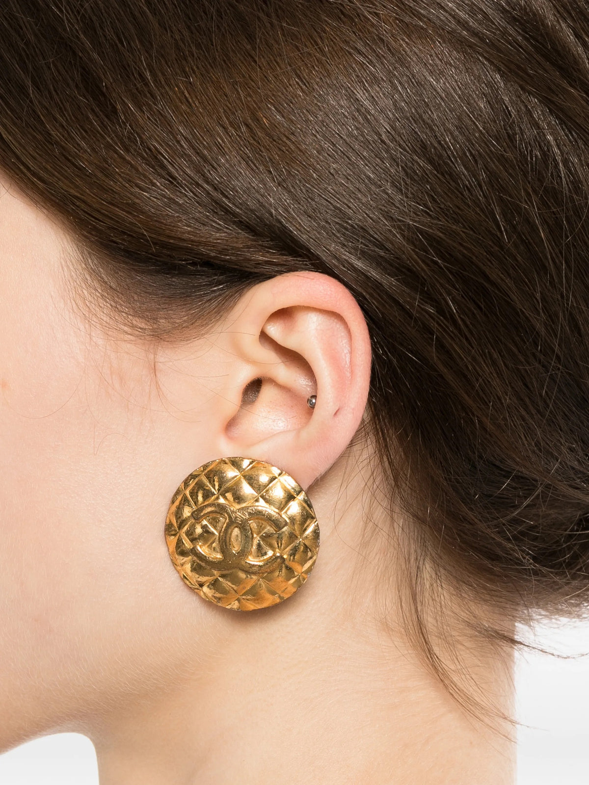 Chanel quilted gold clip-on earrings with a textured, luxurious design, showcasing elegant jewelry for fashionable accessories.