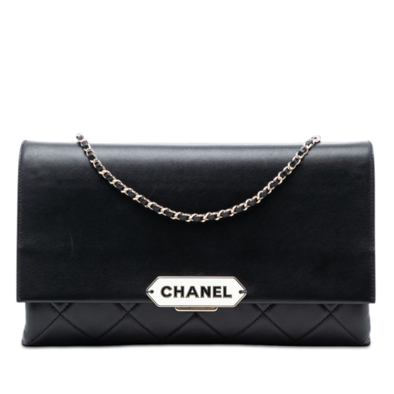 Chanel black quilted lambskin retro clutch bag with fold-over flap, front Chanel logo plaque, silver-tone chain detail and slim rectangular silhouette.