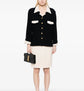 Chanel single-breasted bouclé skirt suit set featuring a tailored blazer and matching skirt in textured fabric.