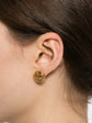 Chanel small gold emblem clip-on earrings featuring a classic brand logo design on a plain background.