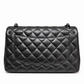 Black Chanel quilted jumbo double flap shoulder bag made of crumpled lambskin with a classic quilted design and silver hardware.