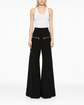 Chloé flared zip trousers featuring high waist, wide leg design, and front zipper detail, shown in a stylish fashion photograph.