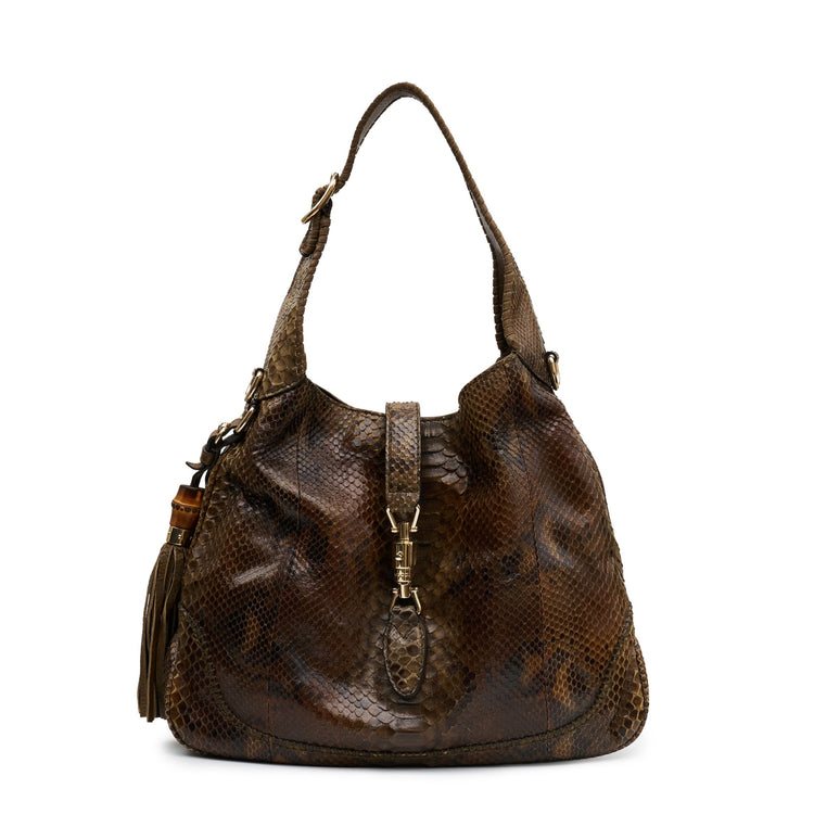 Gucci medium Jackie hobo shoulder bag with beige and black leather, gold-tone hardware, and signature GG logo detail.