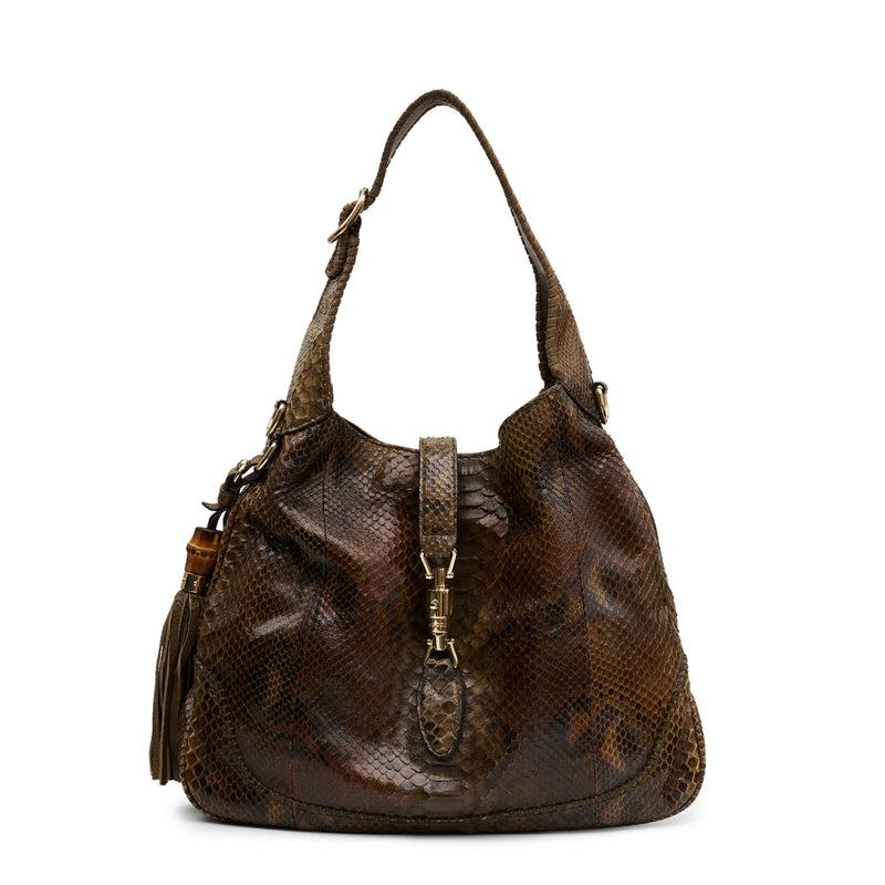 Gucci medium Jackie hobo shoulder bag with beige and black leather, gold-tone hardware, and signature GG logo detail.
