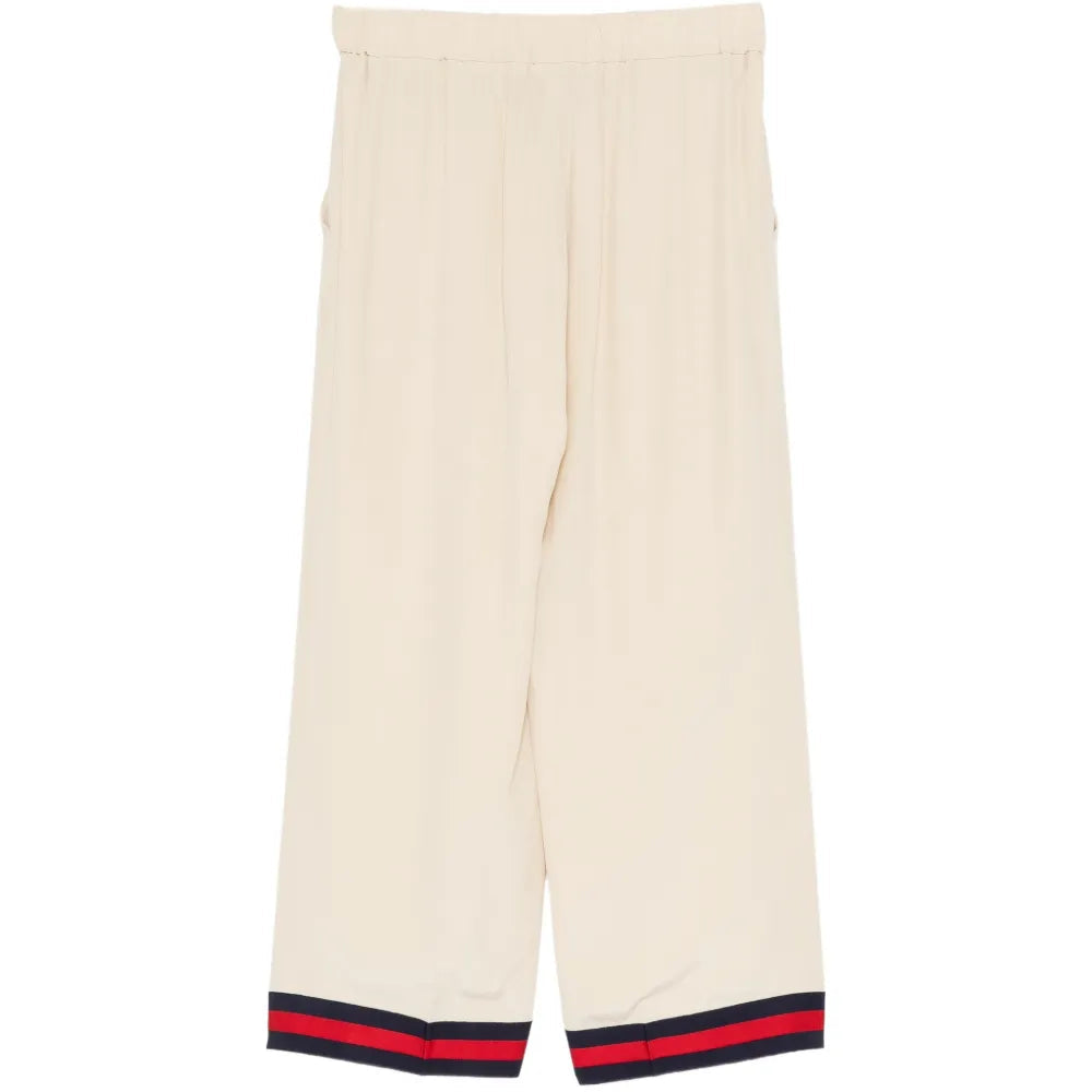 Gucci silk wide-leg trousers shown on a model with a smooth, flowing fabric and elegant design.