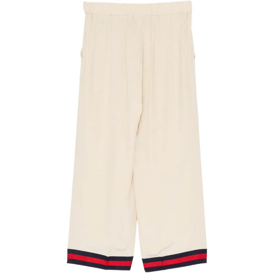 Gucci silk wide-leg trousers shown on a model with a smooth, flowing fabric and elegant design.