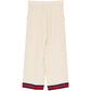 Gucci silk wide-leg trousers shown on a model with a smooth, flowing fabric and elegant design.