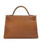 Hermès Kelly 40 Gold PHW top handle bag with structured silhouette and gold hardware, featuring a sleek, luxurious design.