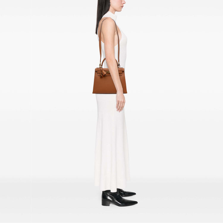 Hermès Kelly II Sellier 28 bag in Gold Epsom leather with gold-tone hardware, white contrast stitching, rolled top handle, detachable shoulder strap, front flap, belted straps, clochette, and padlock.