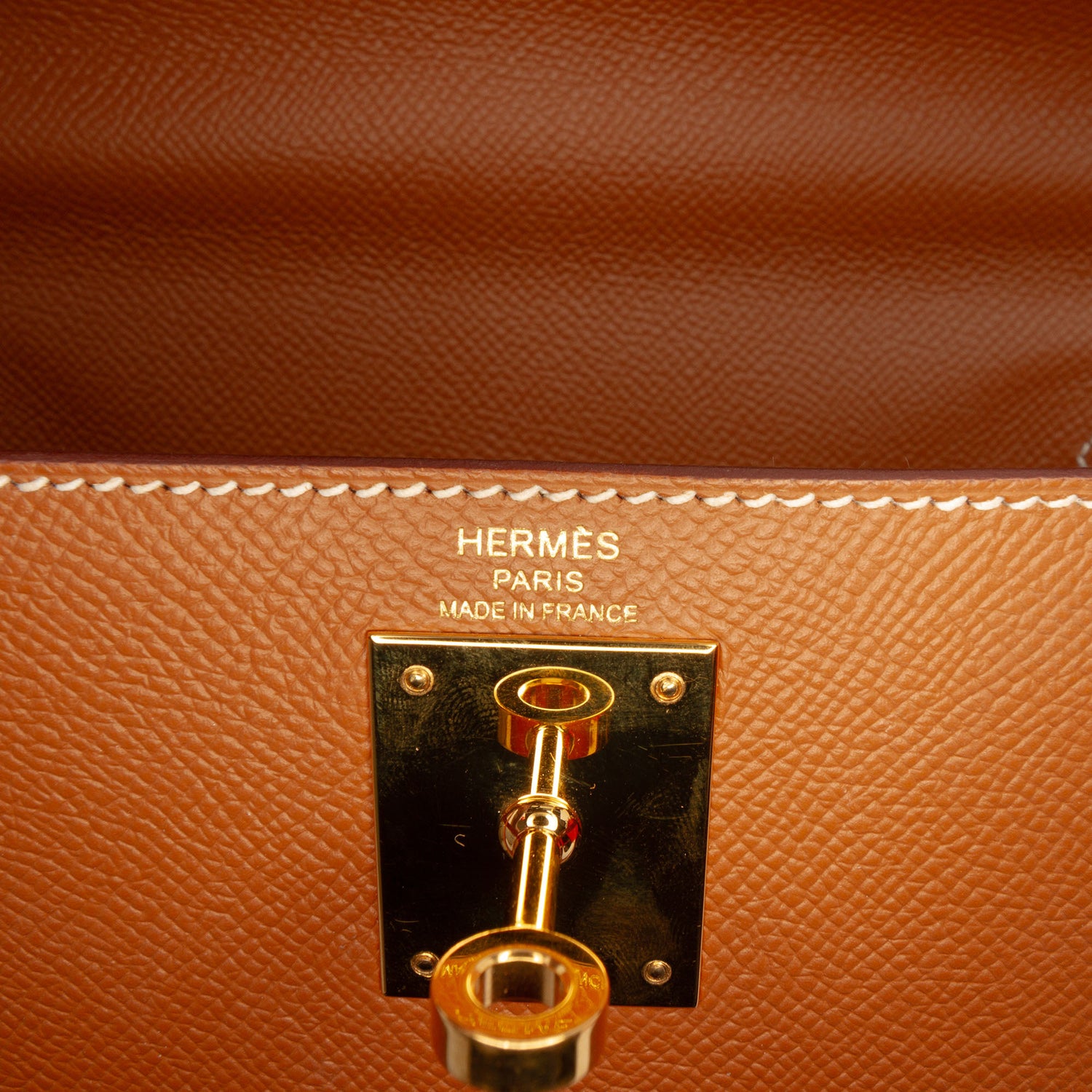 Hermès Kelly II Sellier 28 bag in Gold Epsom leather with gold-tone hardware, white contrast stitching, rolled top handle, detachable shoulder strap, front flap, belted straps, clochette, and padlock.