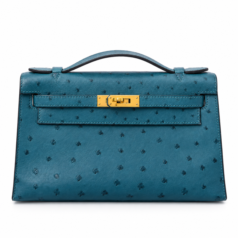 Hermès Kelly Pochette in Bleu Colvert ostrich leather with gold hardware, showcasing elegant handbag design and craftsmanship.