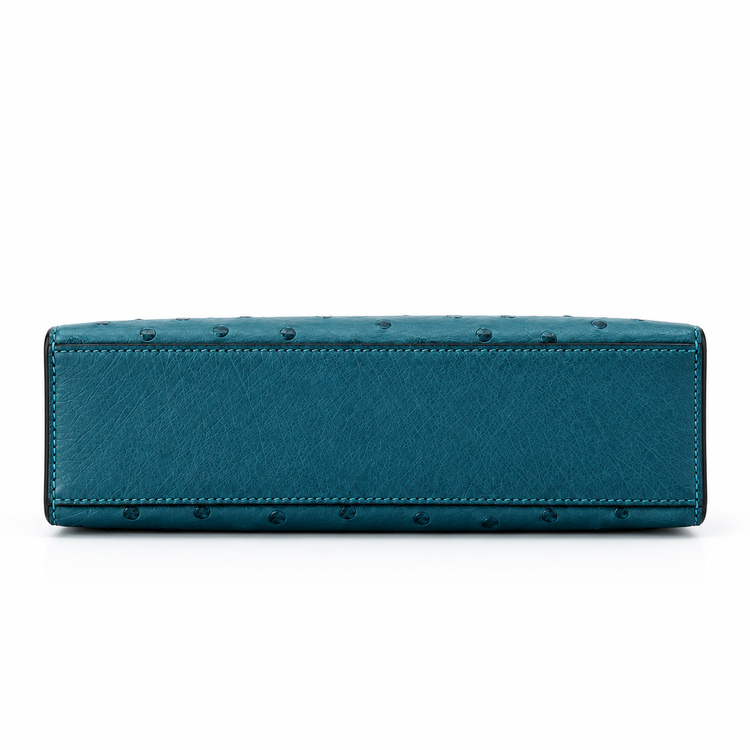 Hermès Kelly Pochette in Bleu Colvert ostrich leather with gold hardware, showcasing the elegant handbag&