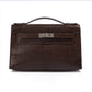 Hermès Chocolat Niloticus Lizard Kelly Pochette handbag with sleek design and elegant leather details.