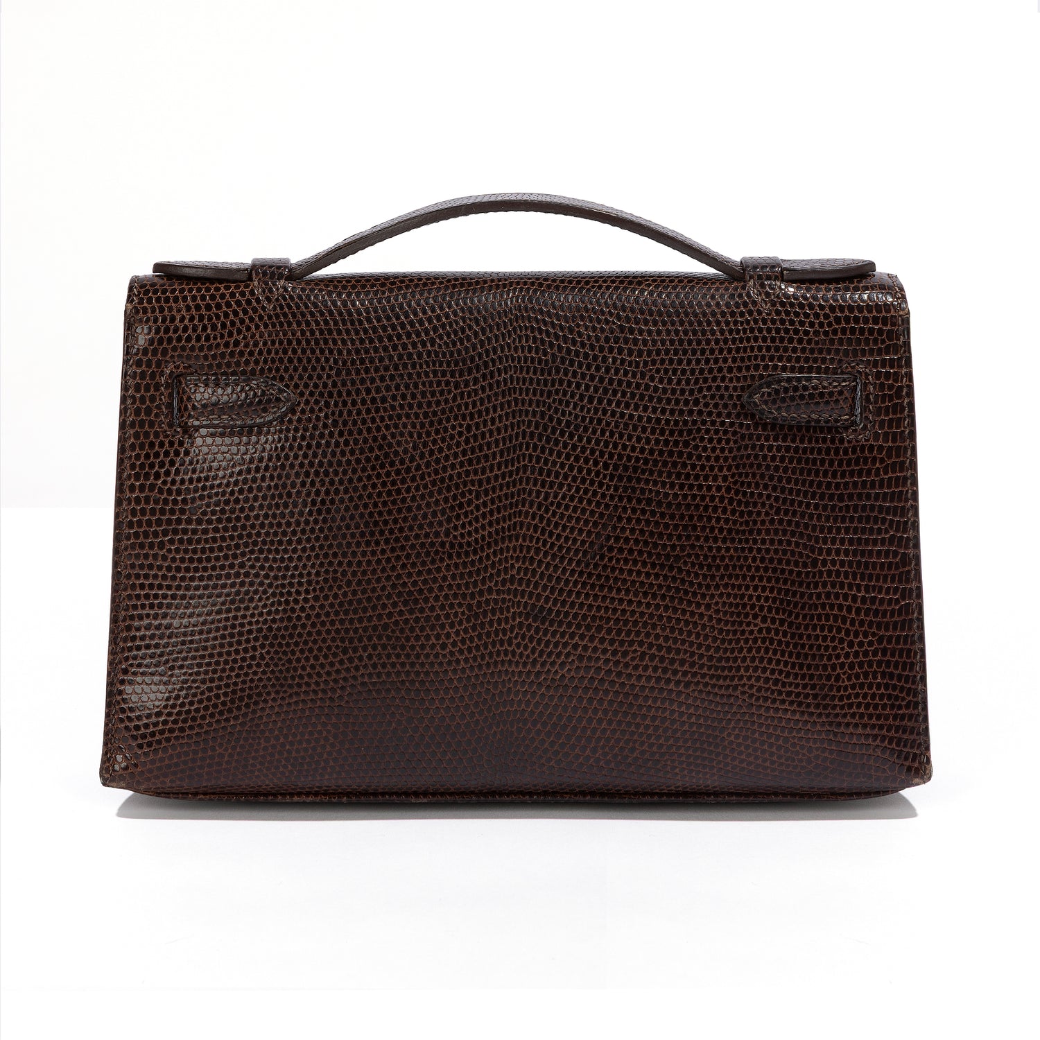 Hermès Chocolat Niloticus lizard Kelly Pochette handbag showing the back view with luxurious chocolate-colored leather and elegant design.