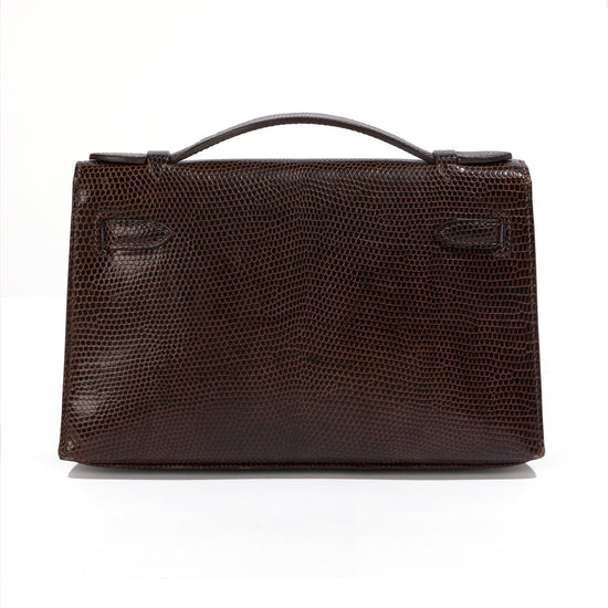 Hermès Chocolat Niloticus lizard Kelly Pochette handbag showing the back view with luxurious chocolate-colored leather and elegant design.