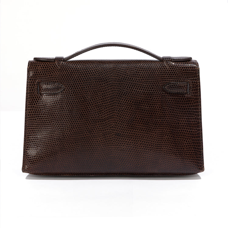 Hermès Chocolat Niloticus lizard Kelly Pochette handbag showing the back view with luxurious chocolate-colored leather and elegant design.