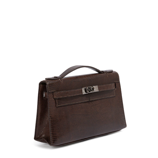Hermès Chocolat Niloticus lizard Kelly Pochette handbag shown from side view, showcasing luxurious exotic leather and elegant design.
