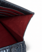 Close-up detail of a dark textured leather wallet or card holder showing the deep burgundy red interior lining and card slots on a white background.