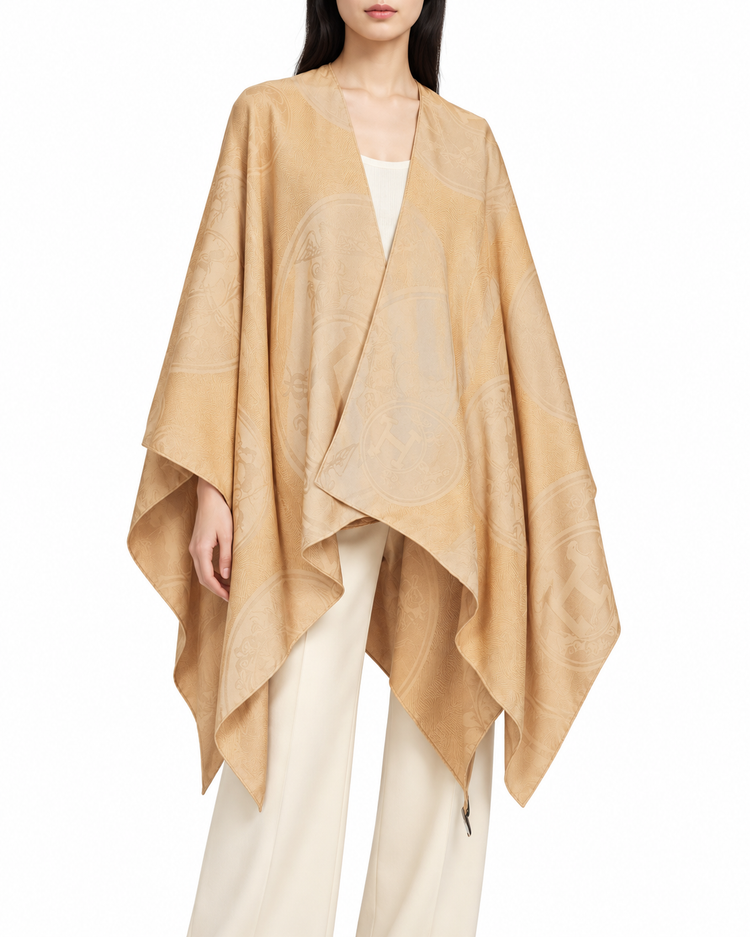 Hermès Cashmere New Libris Poncho scarf in soft, luxurious beige with subtle branding and elegant drape.