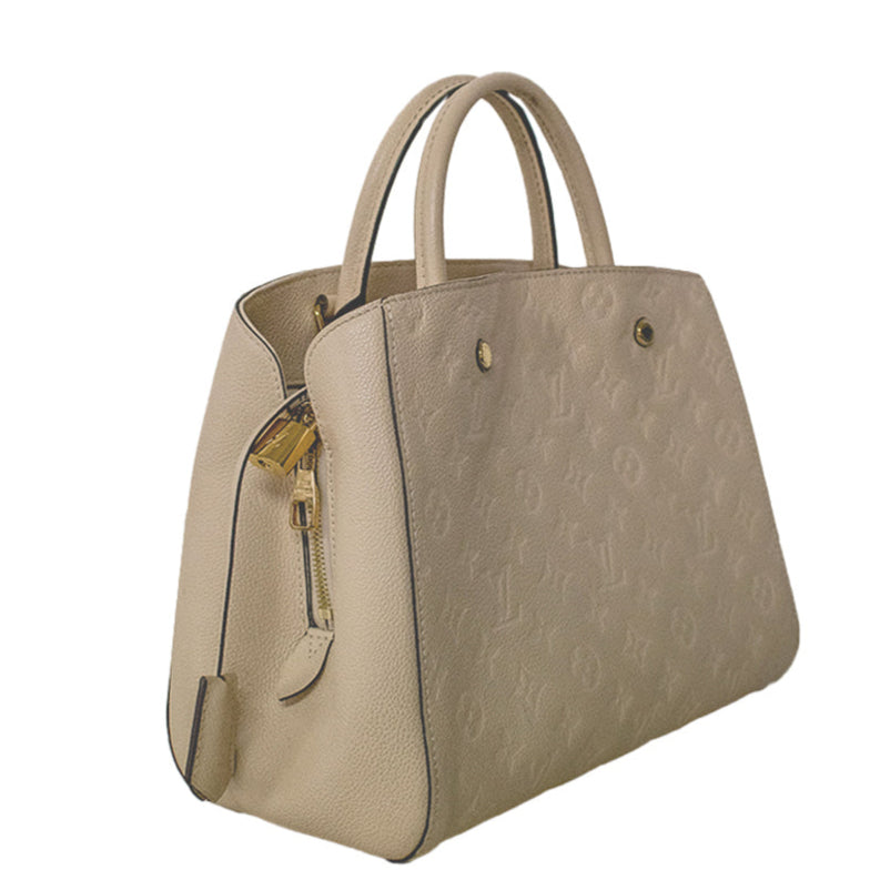 Louis Vuitton Montaigne beige leather handbag with embossed Monogram pattern, structured silhouette, dual top handles and gold-tone hardware.