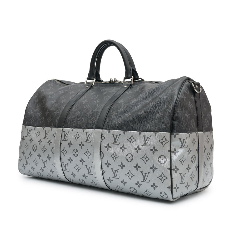 Louis Vuitton Eclipse Monogram Keepall Bandoulière 50 in grey and black Monogram canvas with rolled top handles, zip-top silver and oversized Louis Vuitton logo detail.