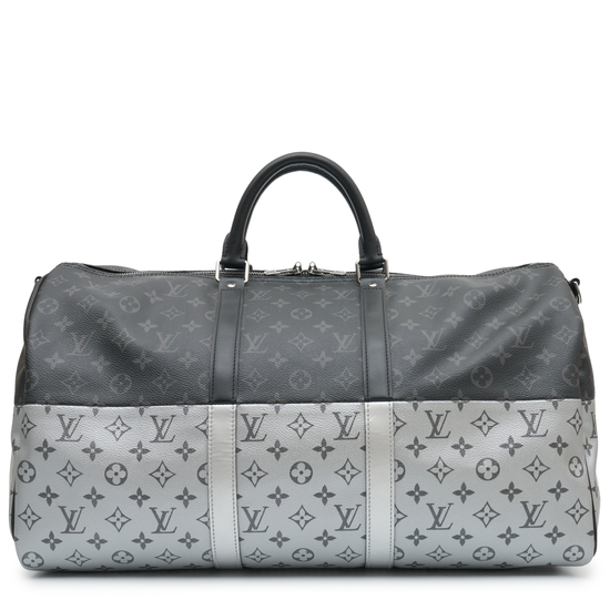Louis Vuitton Eclipse Monogram Keepall Bandoulière 50 in grey and black Monogram canvas with rolled top handles, zip-top silver and oversized Louis Vuitton logo detail.