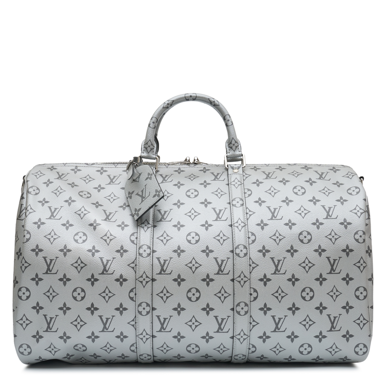 Louis Vuitton Metallic Monogram Keepall Bandoulière 50 in silver Monogram canvas with rolled top handles, silver-tone hardware, top zip closure and matching luggage tag.