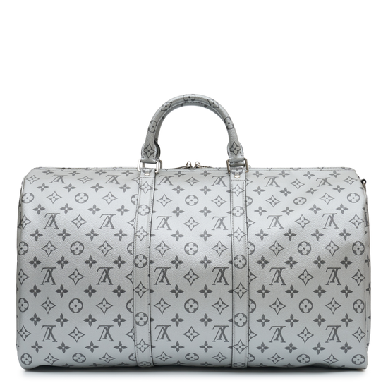 Louis Vuitton Metallic Monogram Keepall Bandoulière 50 in silver Monogram canvas with rolled top handles, silver-tone hardware, top zip closure and matching luggage tag.