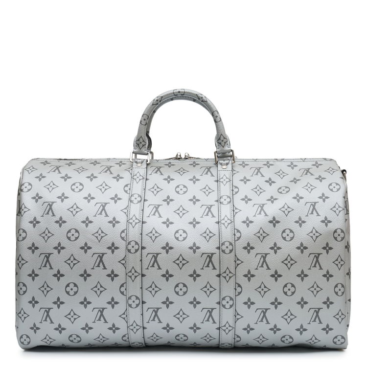 Louis Vuitton Metallic Monogram Keepall Bandoulière 50 in silver Monogram canvas with rolled top handles, silver-tone hardware, top zip closure and matching luggage tag.